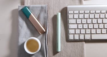 Green and coppery IQOS 3 MULTI kit on a working desk