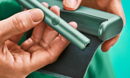 IQOS ILUMA PRIME w kolorze Jade Green w dłoniach