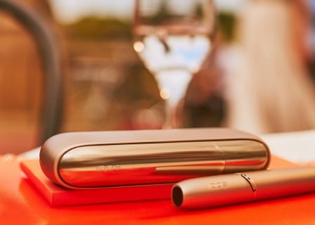 IQOS 3 DUO holder and charger on a dinner table