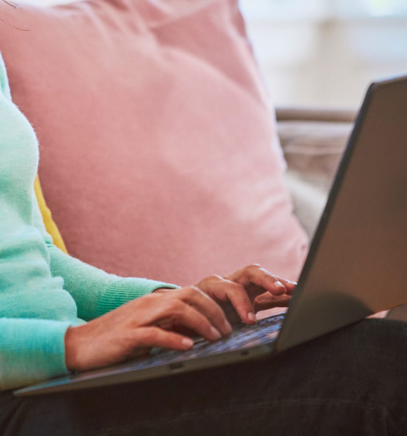 Osoba trzymająca laptopa na kolanach