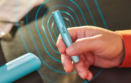 Podgrzewacz IQOS ILUMA i PRIME z ekranem dotykowym trzymany w dłoni