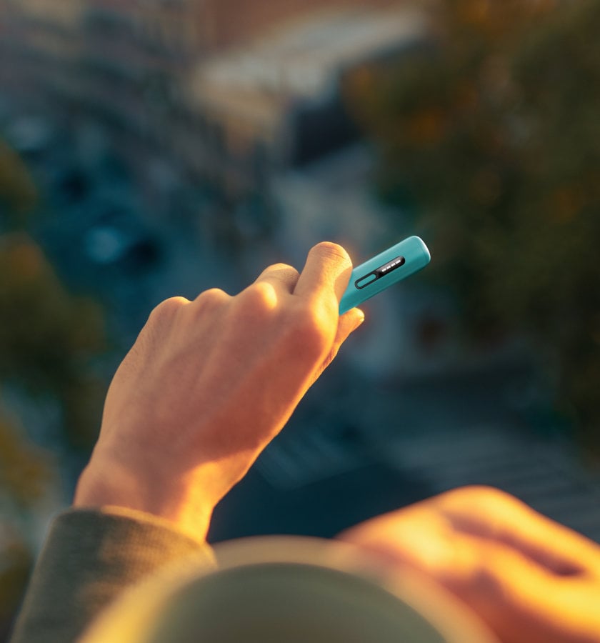 Podgzewacz tytoniu IQOS ILUMA i ONE w kolorze Breeze Blue, trzymany w dłoni