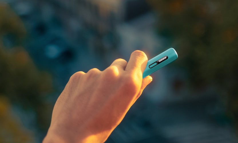 Podgrzewacz tytoniu IQOS ILUMA i ONE w kolorze Breeze Blue, trzymany w dłoni
