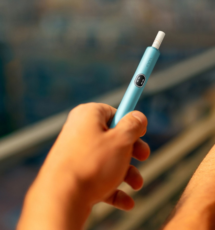 Podgrzewacz IQOS ILUMA i z włożonym wkładem tytoniowym trzymany w dłoni