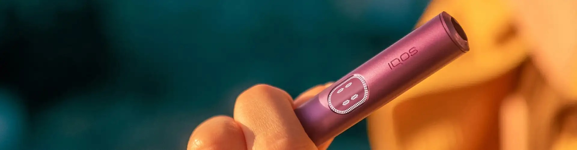 Podgrzewacz IQOS ILUMA i z widocznym ekranem dotykowym trzymany w dłoni