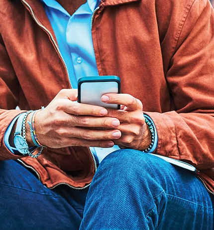 Mężczyzna trzyma w przed sobą telefon