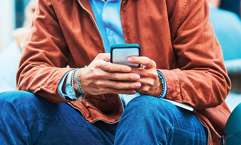 Mężczyzna trzyma w przed sobą telefon