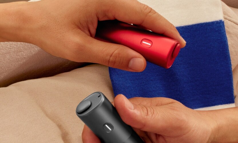 Podgrzewacze tytoniu BONDS by IQOS, czarny i czerwony, trzymane w dłoniach