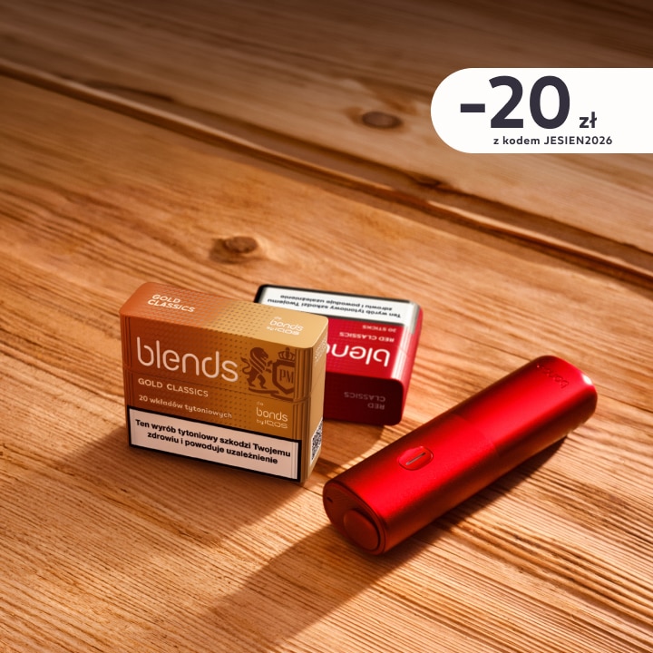 BONDS by IQOS w kolorze czerwonym obok 2 paczek wkładów tytoniowych Blends na drewnianym stole