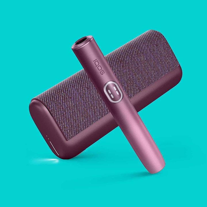 Podgrzewacz i przenośna ładowarka IQOS ILUMA i, czerwone, na turkusowym tle