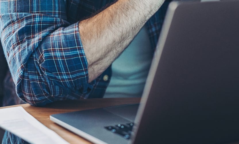 Osoba siedząca przy laptopie