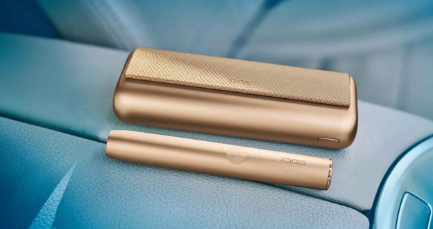 IQOS ILUMA PRIME golden khaki na desce rozdzielczej