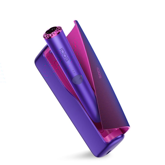 Podgrzewacz IQOS ILUMA Neon Purple widoczny w otwartej przenośnej ładowarce w limitowanej edycji, lekko zagięte etui